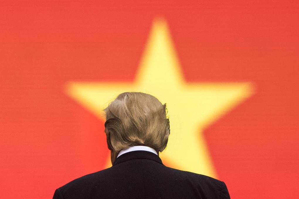 US President Donald Trump stands in front of the Vietnamese flag during an arrival ceremony in Hanoi in 2017. Photo: AFP
