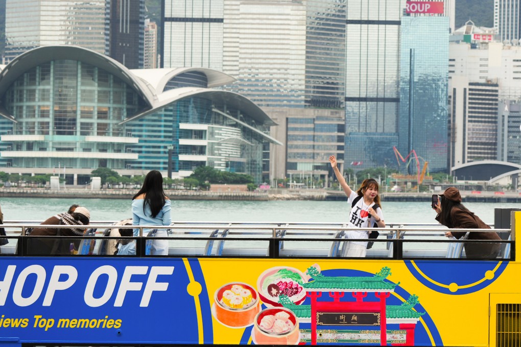 A tourist takes a photo from an open-top bus on November 21, 2024. Photo: May Tse