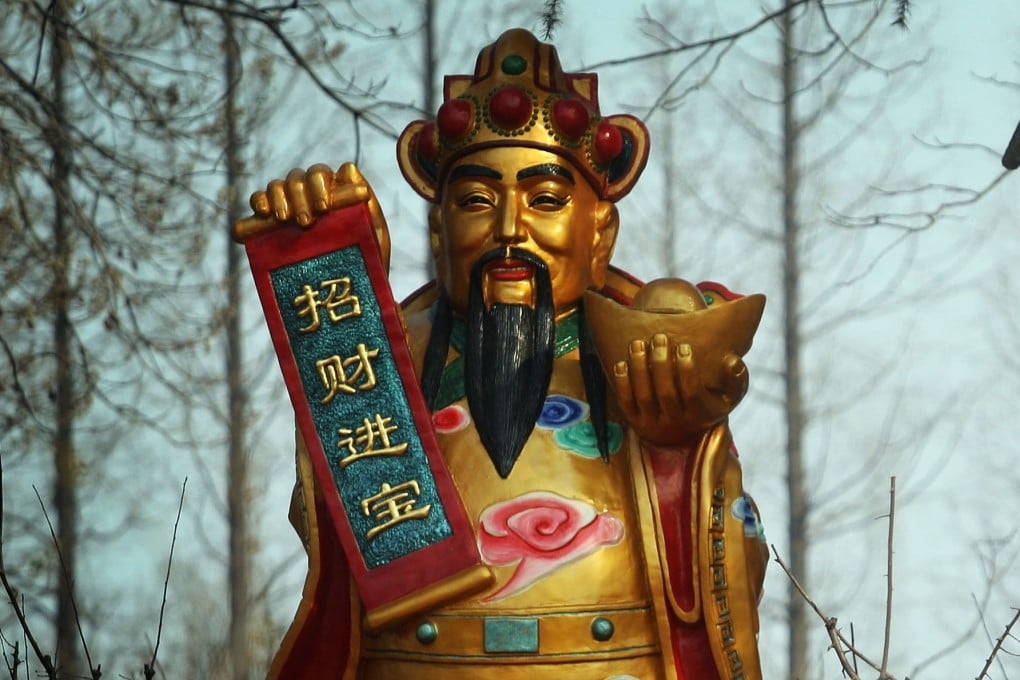 A statue of the god of wealth stands in a forest in Nanjing, in China’s Jiangsu province. The god is one of the many guardian deities that Chinese people traditionally pray to during Lunar New Year for fortune, health, love and prosperity. Photo: Getty Images