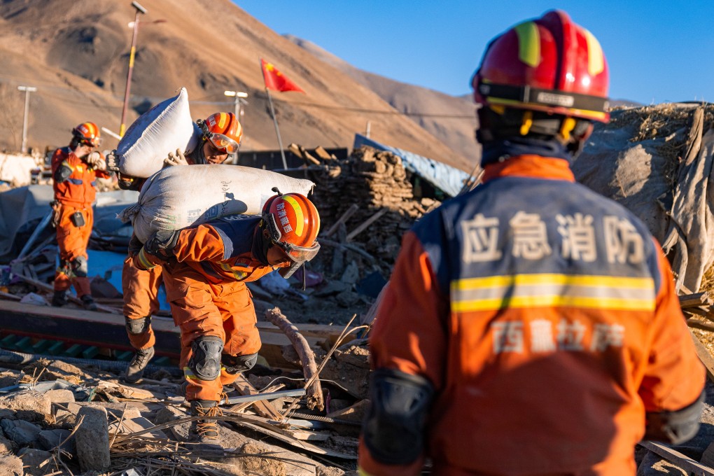 Firefighters carry barley in the village of Gurong, in Dingri county, Tibet, following a magnitude 6.8 earthquake on January 7. The quake caused extensive damage to communication infrastructure. Photo: Xinhua