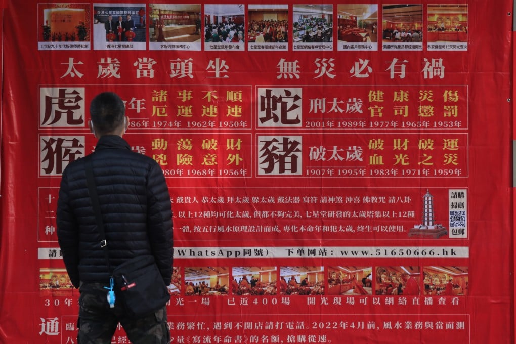 A man stops to read an advertisement in Yau Ma Tei in 2021 for a feng shui master’s services for Chinese zodiac signs facing a challenging year. Photo: Xiaomei Chen