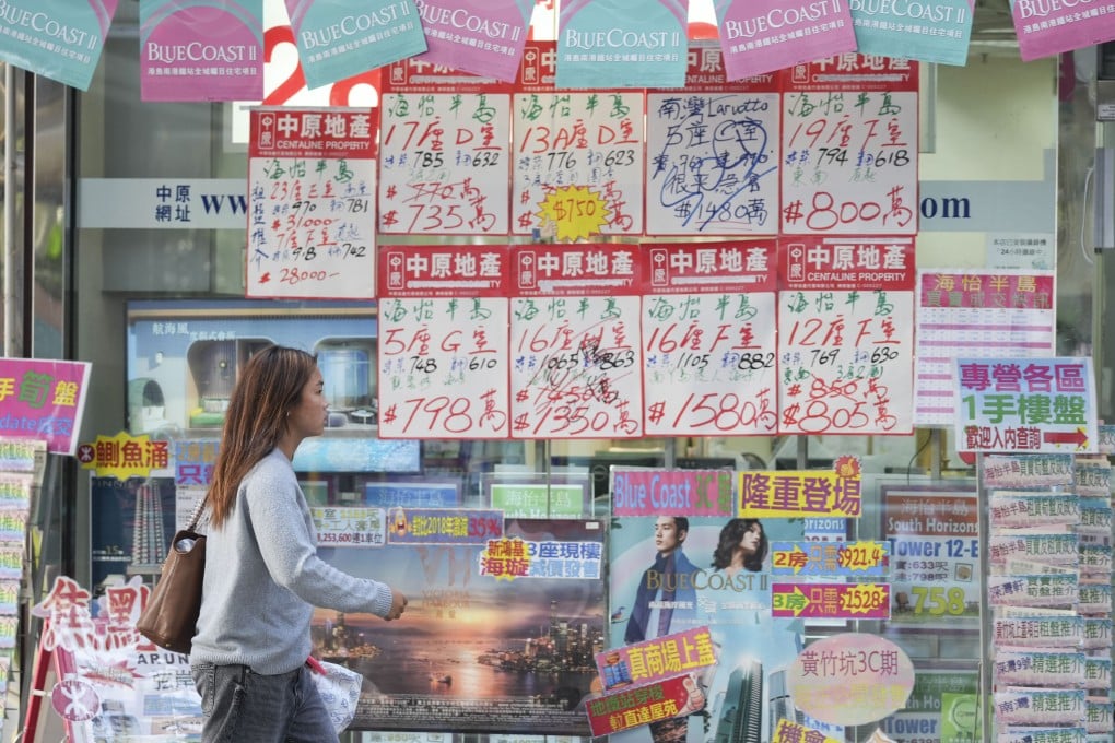 A woman walks past a property agency in South Horizons, Hong Kong. Photo: Eugene Lee