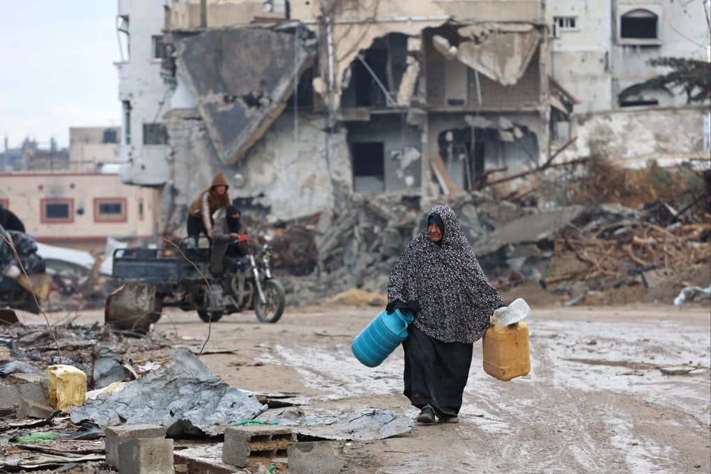 A woman walks past building rubble as displaced Palestinians return to the northern areas of the Gaza Strip, in Jabalia, on Thursday, during a ceasefire in the war between Israel and Hamas. Photo: AFP