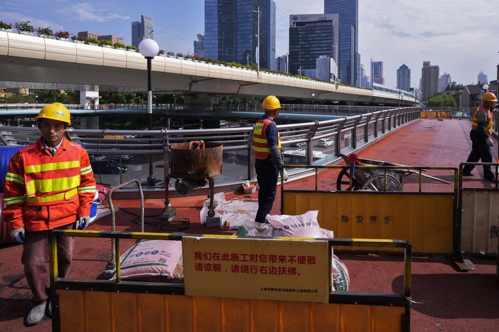 Workers refurbish an overhead pedestrian bridge in Shanghai on October 9, 2024. Photo: AP