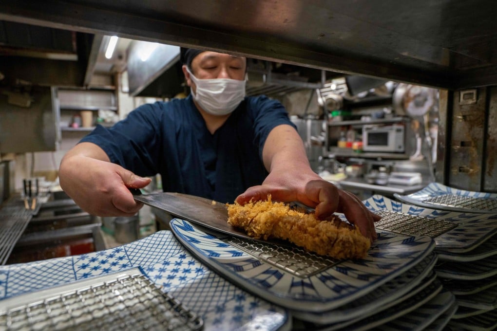 Chef Katsumi Shinagawa prepares a pork cutlet dish at his restaurant in Tokyo on January 21. Photo: AFP