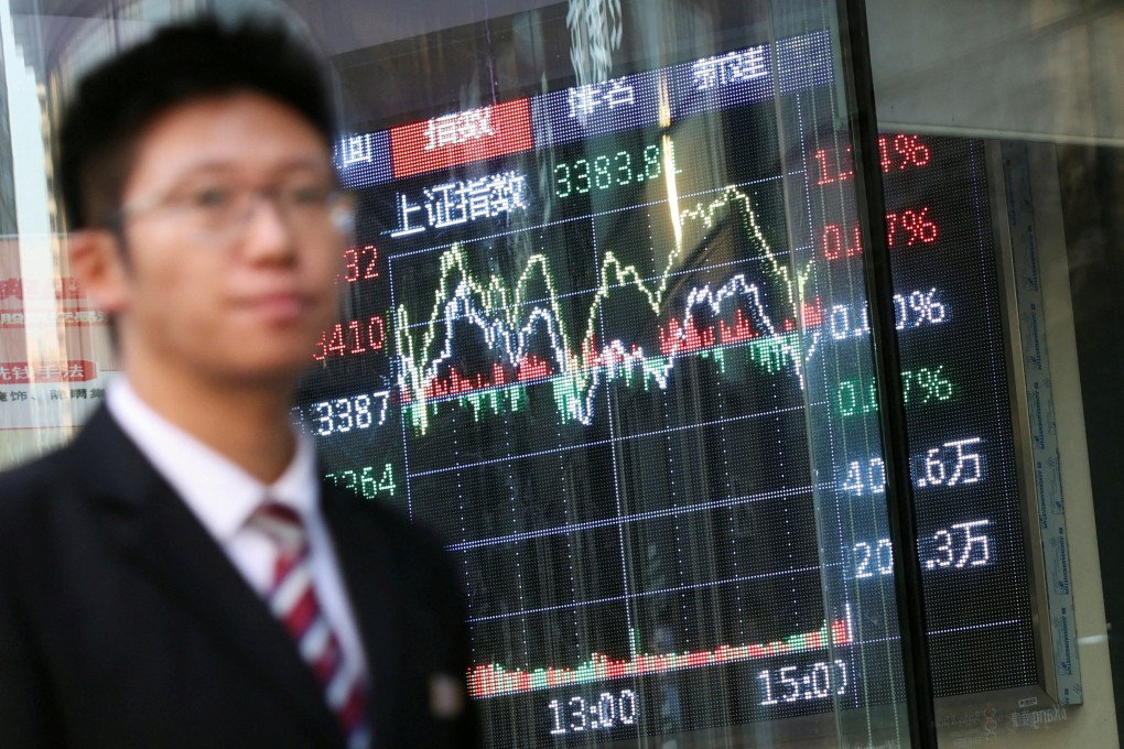 A man walks past a brokerage house with a display showing stock information in Beijing. Photo: Reuters