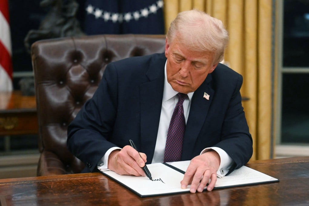 US President Donald Trump signs an executive order in the Oval Office of the White House in Washington on January 20. Photo: Getty Images
