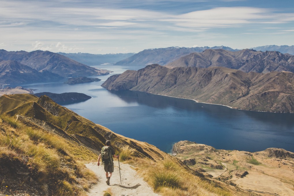 A man hikes at Roys Peak near Lake Wanaka on New Zealand’s South Island. Photo: Getty Images