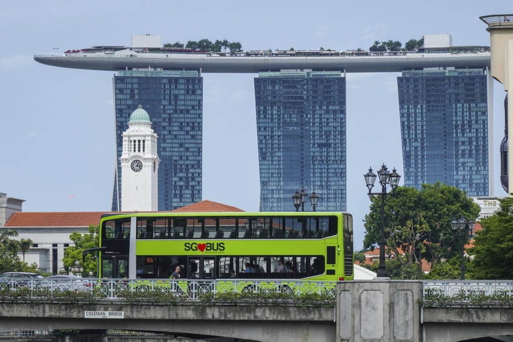 A public bus passes a bridge in Clarke Quay in front of the Marina Bay Sands Hotel in Singapore. Photo: SCMP