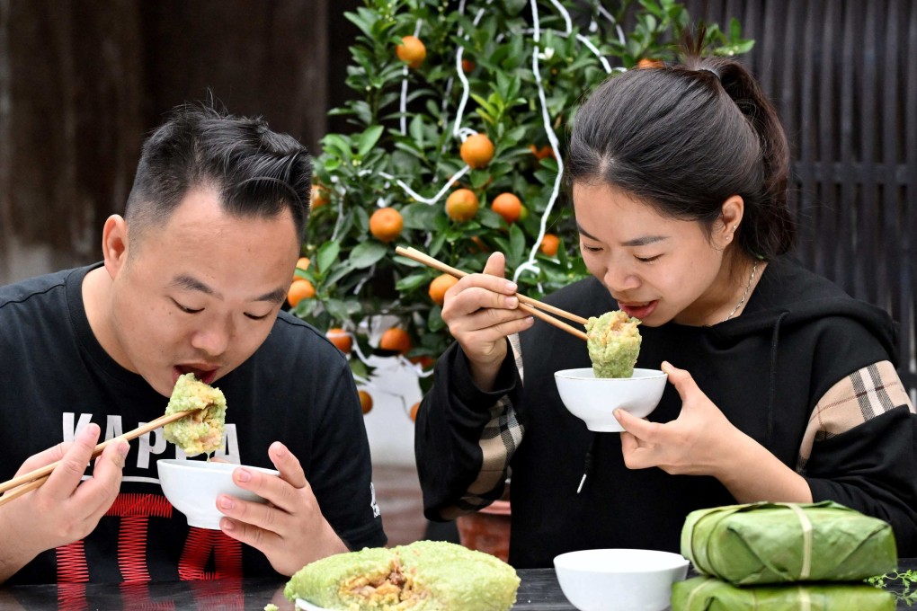 A couple eat “banh chung” at their home in Hanoi. Photo: AFP