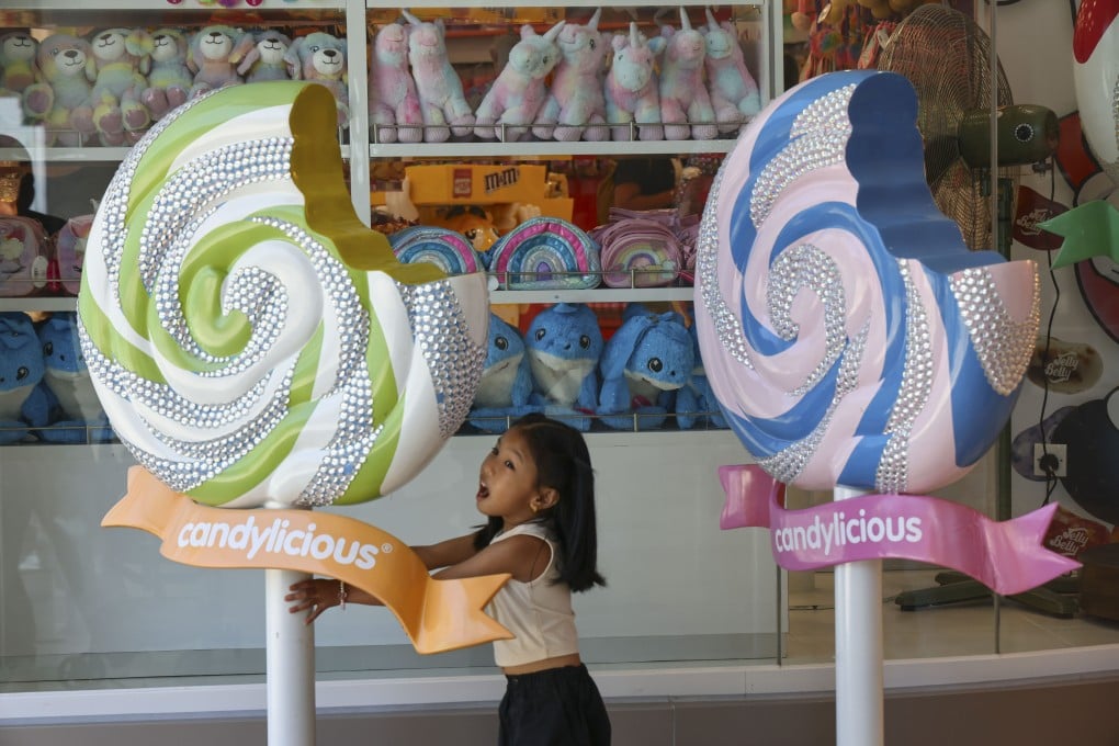A girl plays among candy decorations outside a shop at Peak Galleria in Hong Kong on August 4, 2024. Photo: Dickson Lee