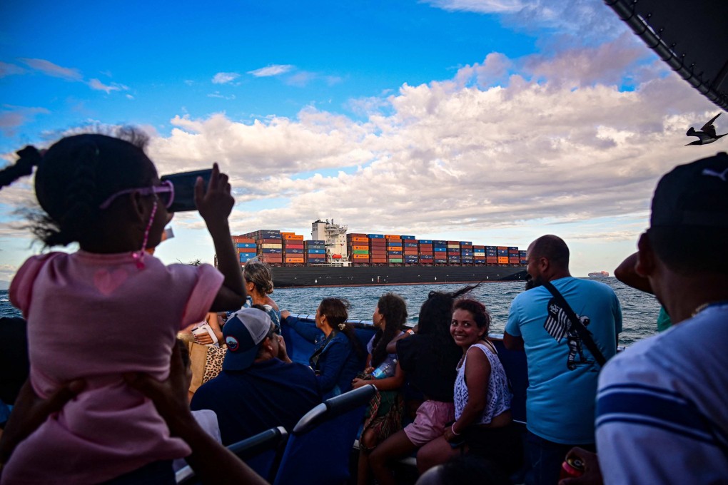 Tourists look at a cargo ship waiting to enter the Panama Canal on Saturday. Photo: AFP