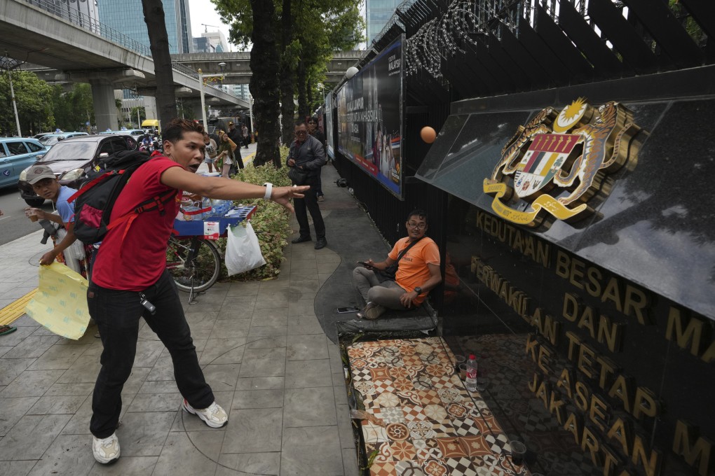 A protester throws eggs in front of the Malaysian embassy in Jakarta. Photo: AP