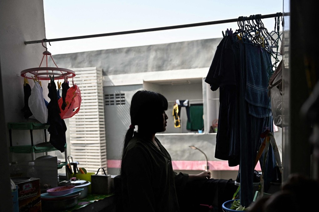 A Myanmar migrant worker looks out her flat window in Samut Sakhon province, Thailand. Photo: AFP