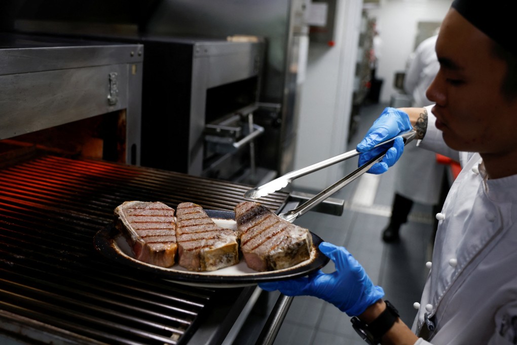 A chef cooks beef steaks at the kitchen of Wolfgang’s Steakhouse restaurant in Beijing in 2021. Photo: Reuters