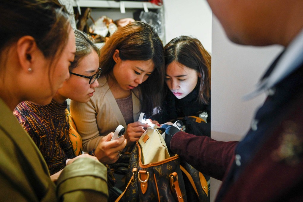 Trainees practice methods in verifying the authenticity of a handbag following a class at the Extraordinary Luxuries Business School in Beijing, where there is a big market for luxury goods and their counterfeit equivalents. File photo: AFP
