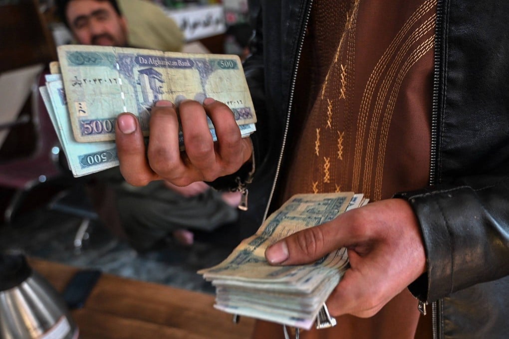 An Afghan money changer counts banknotes at a currency exchange market in Kabul on January 26. Photo: AFP