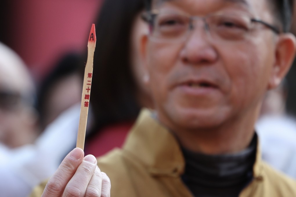 Kenneth Lau, chairman of Heung Yee Kuk, takes part in a fortune stick drawing ritual at Che Kung Temple in Sha Tin on January 30, the second day of Lunar New Year. Photo: Dickson Lee