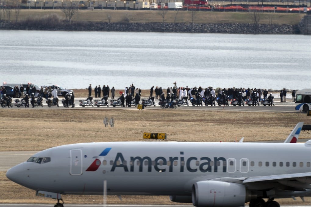 An American Airlines jet passes as families of the victims of last week’s mid-air collision stand near the crash site at Ronald Reagan Washington National Airport in Arlington, Virginia on Sunday. Photo: AP