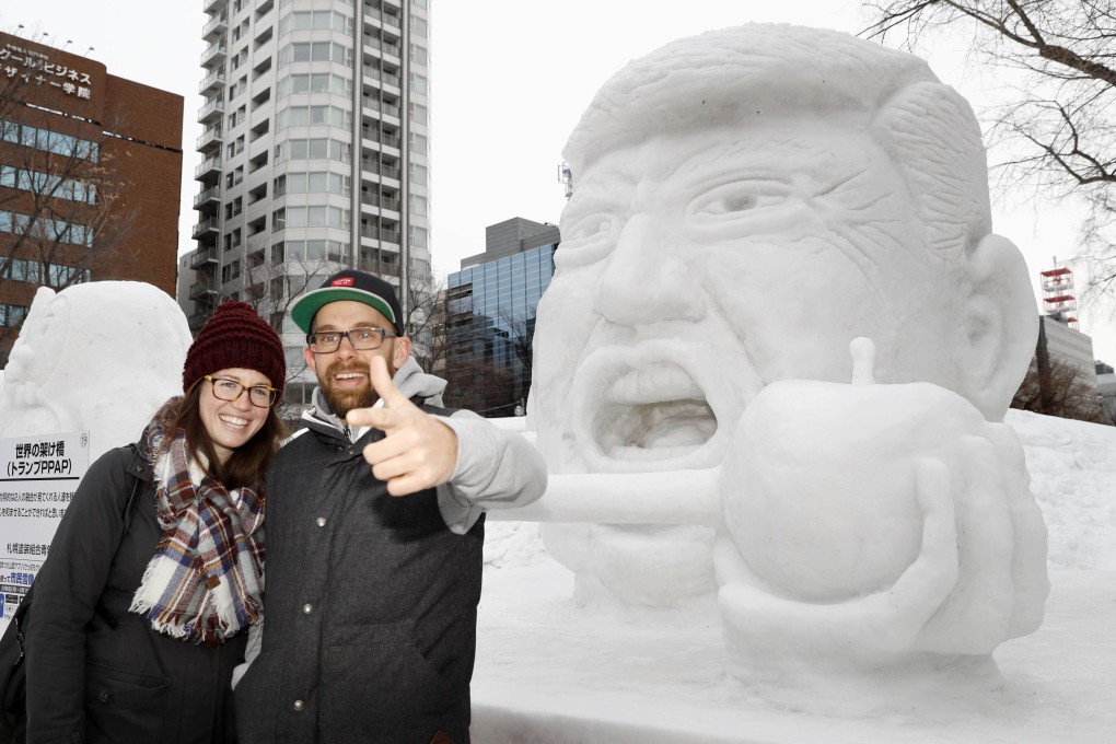 Tourists pose for photos in front of a snow statue of US President Donald Trump at Sapporo Snow Festival in 2017. Photo: Kyodo