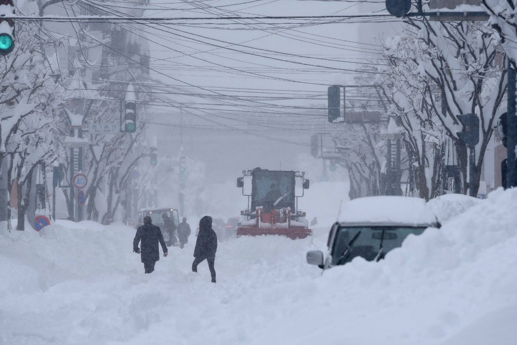 Heavy machinery is used to clear a road in the city of Obihiro, Hokkaido prefecture, on Tuesday as snow falls across northern Japan. Photo: Jiji Press/AFP