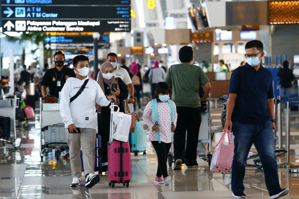 People walk with their luggage at Soekarno-Hatta Airport in Jakarta. Photo: Reuters
