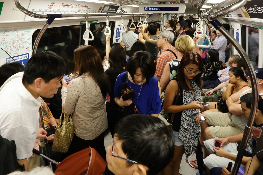 Commuters pack a train in Singapore. A recent post about the smell of sweaty bodies during a morning commute ignited fierce debate on social media in the country. Yet hot running water piped to one’s home is a relatively recent invention. Before that, few bathed daily. Photo: 
 Suhaimi Abdullah/Getty Images