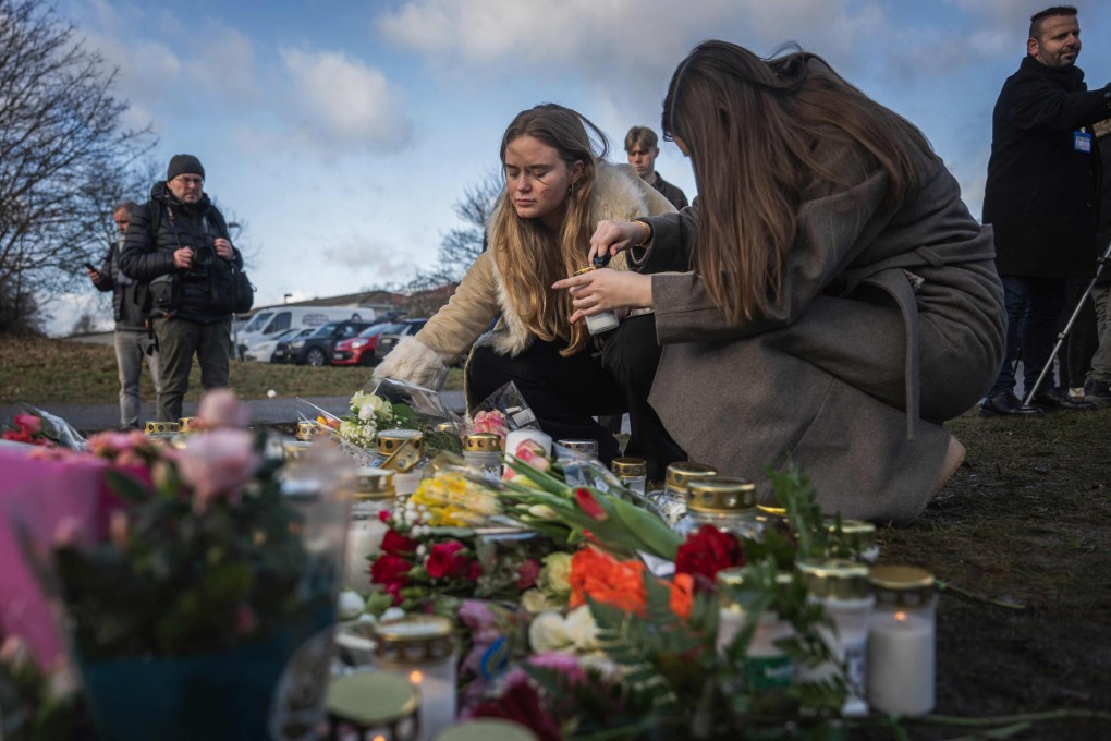 People light candles at a makeshift vigil near Campus Risbergska in Orebro, Sweden, on Wednesday. Photo: AFP
