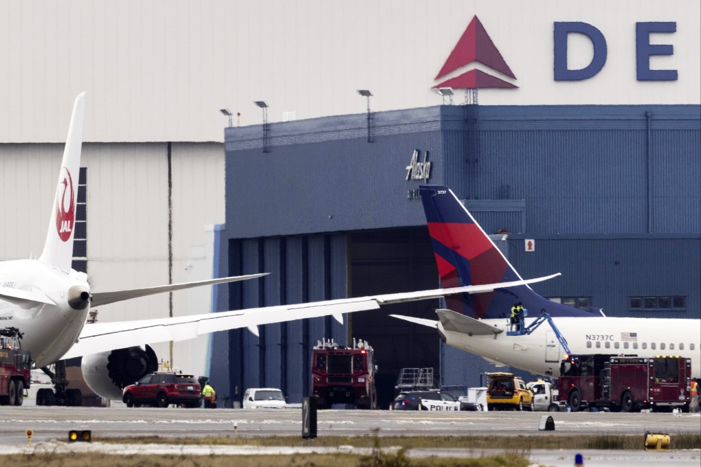Workers check the area where the wing of a Japan Airlines jet went into the tail of a Delta Air Lines jet at Seattle-Tacoma International Airport on Wednesday. Photo: The Seattle Times via AP
