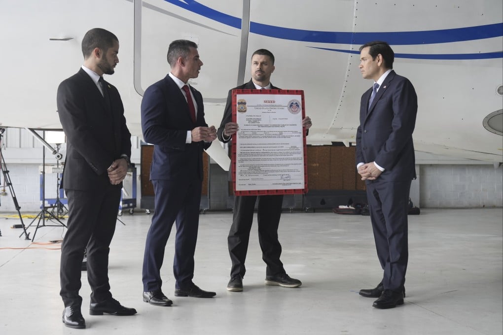 US Secretary of State Marco Rubio, right, listens to Edwin F Lopez, of DHS Homeland Security Investigations, second from left, next to the Venezuelan government plane that Rubio said is being seized by the US, at La Isabela International Airport in Santo Domingo, Dominican Republic on Thursday. Photo: AP