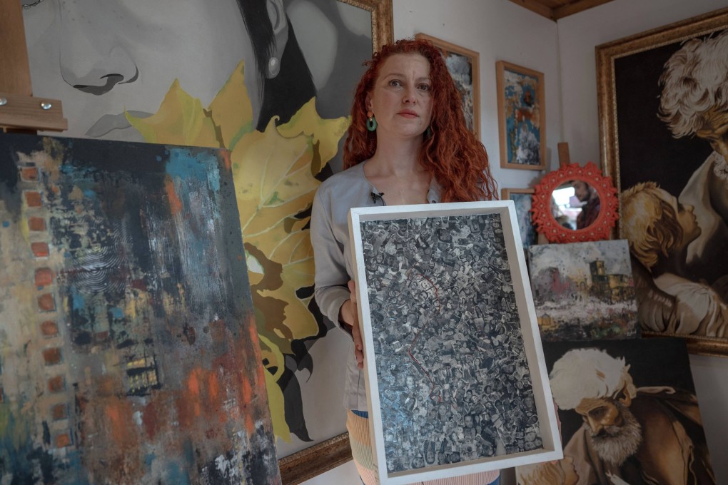 Turkish artist Emil Genc with her paintings in her workshop at the Antakya Art and Culture Market, which showcases the work of more than 70 local artists two years after an earthquake killed 53,000 people. Photo: AFP