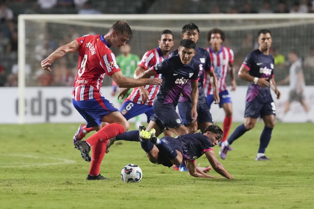 Jay Haddow leaps into a challenge on Alexander Sorloth during Kitchee’s pre-season clash with Atletico Madrid. Photo: Sam Tsang