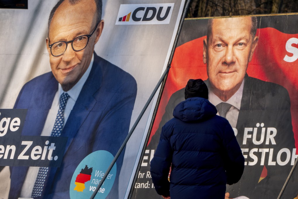A man walks past election posters showing German Chancellor Olaf Scholz, right, and the conservative CDU’s candidate for chancellor Friedrich Merz, in Frankfurt, Germany, on Saturday. Photo: AP