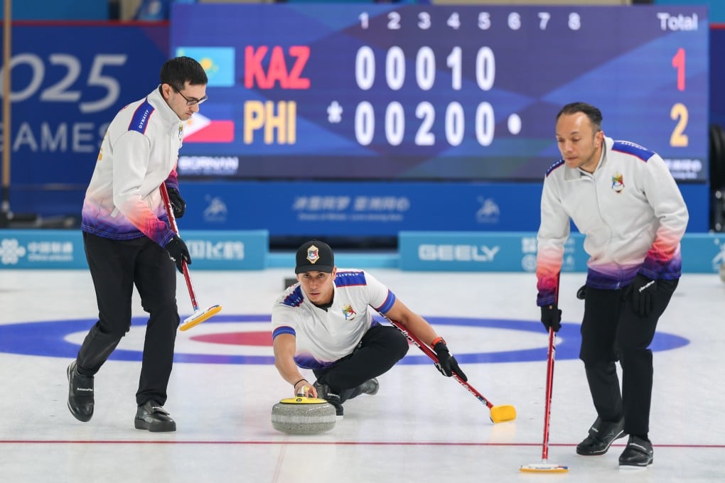 The Philippines Enrico Pfister (centre) curls a stone as the men’s team take on Kazakhstan at the Asian Winter Games in Harbin on Monday. Photo: Xinhua