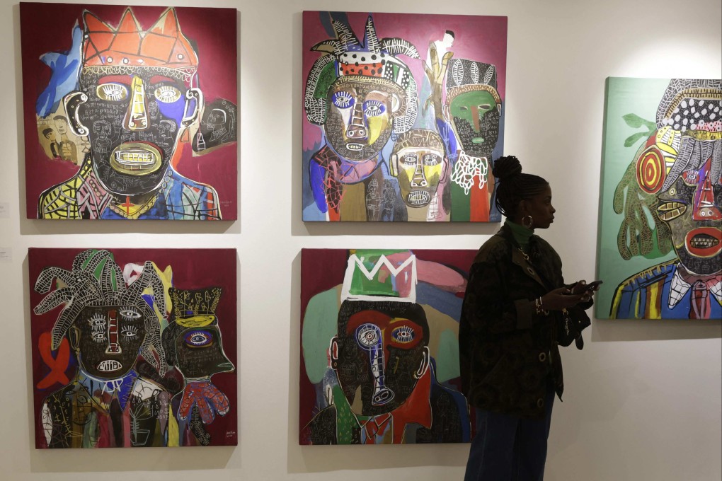 A visitor walks past artworks by Cameroonian artist Hako Hankson during the 1-54 Contemporary African Art Fair in Marrakesh, Morocco, on January 30, 2025. Other well-known artists at the event included Amoako Boafo, Maheder Haileselassie Tadesse, Dina Nur Satti, Chigozie Obi and Adjei Tawiah. Photo: AFP