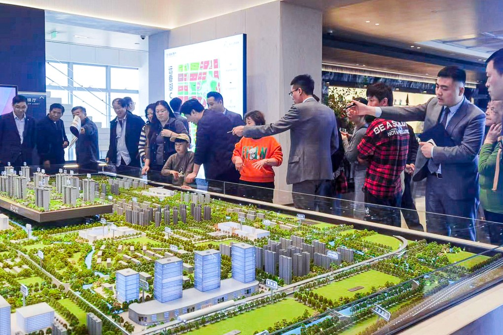 Property agents show potential buyers a model of a residential development in Shanghai on May 28, 2024. Photo: Xinhua