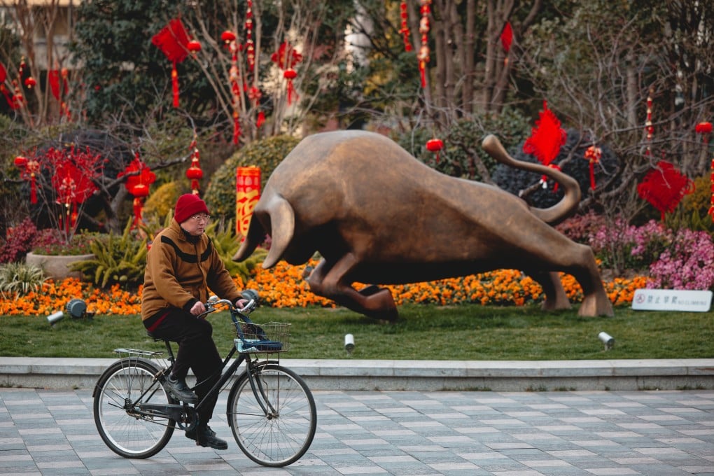 A man cycles by a bull sculpture in a park decorated for the Lunar New Year in Shanghai. Photo: EPA-EFE