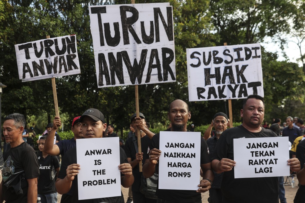 Protesters hold placards outside Malaysian prime minister’s official residence in Putrajaya last June. Photo: EPA-EFE