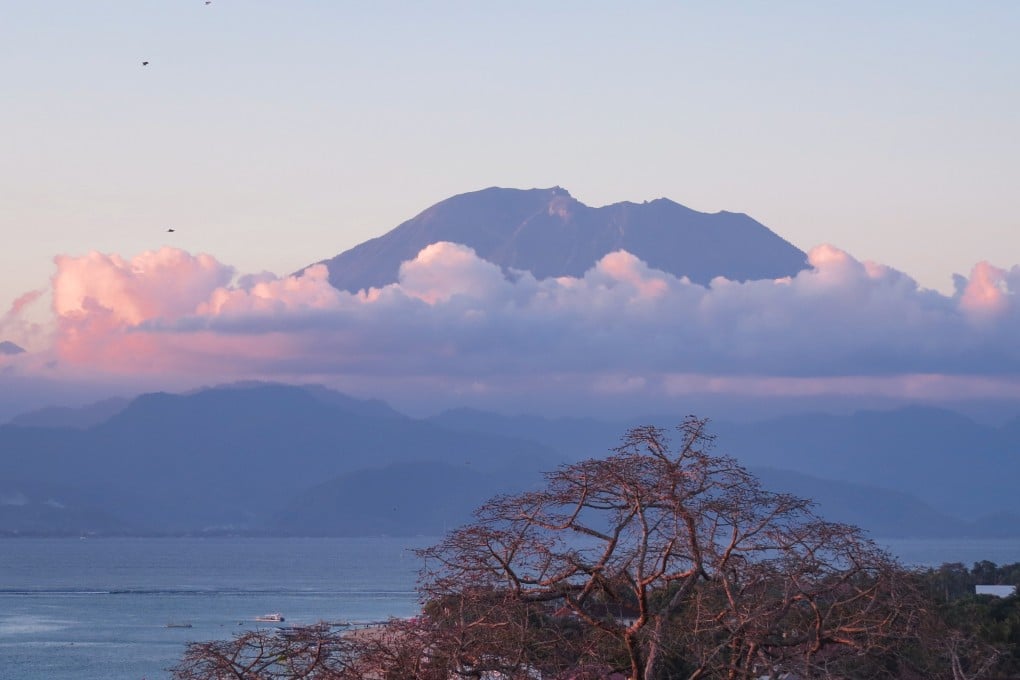 Northeast Bali’s sacred volcano, Mount Agung, casting a sunset glow over Jungut Batu, directly opposite. Photo: Deborah Cassrels