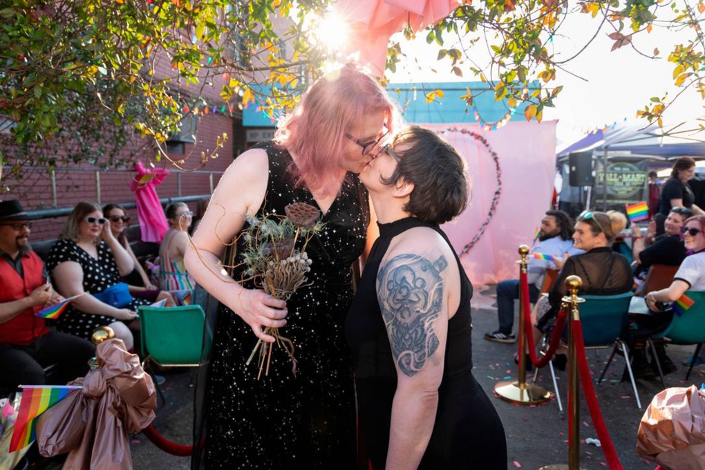 Christine Fowler and her wife Sharon Thrailkill kiss after their wedding at Y’­all-Mart, a quarterly art fair series, at Art Bar, in Columbia, South Carolina. Photo: TNS