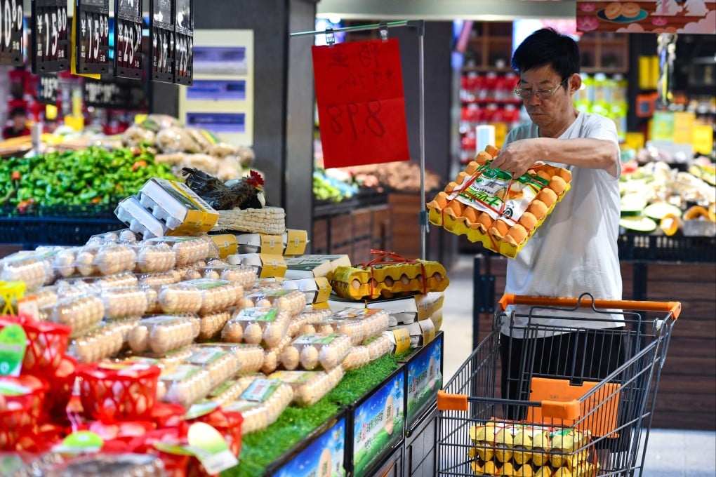 A customer purchases eggs at a supermarket in Fuyang, Anhui province. The prices of eggs and chickens are falling in China amid weak domestic demand. Photo: Getty Images