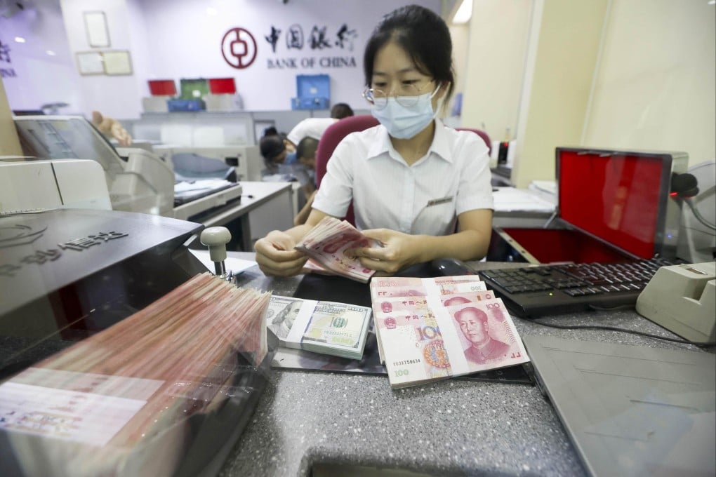 A Bank of China employee counts US and Chinese banknotes at a branch in Taiyuan, Shanxi province, in 2020. Photo: CNS