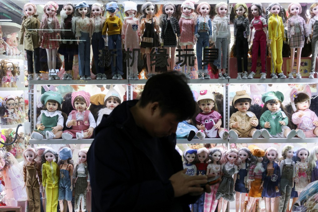 A man stands outside a booth at the giant wholesale market in Yiwu, Zhejiang province. Photo: Reuters
