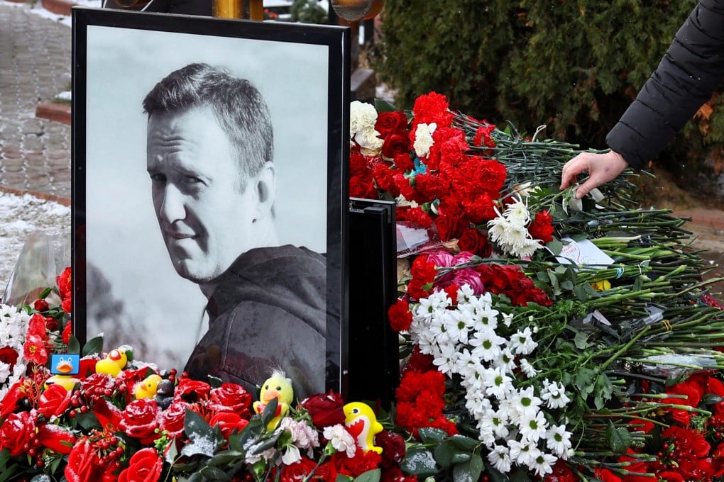 A person lays flowers at the grave of Russian opposition leader Alexei Navalny while marking the first anniversary of his death, at a cemetery in Moscow on Sunday. Photo: Reuters