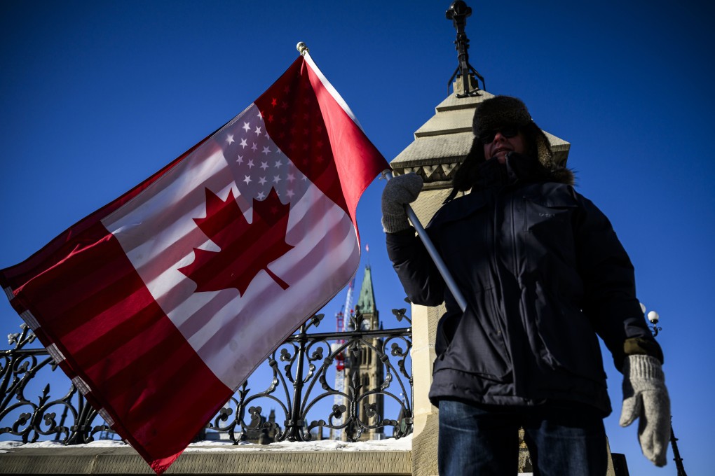 A protester holds Canadian and US flags on Parliament Hill in Ottawa on February 1. Photo: Canadian Press via AP