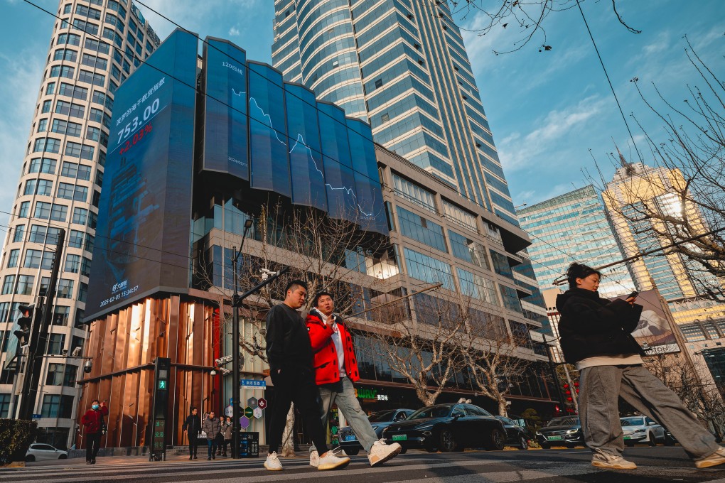 People cross a street near a screen showing stock exchange and economic data in Shanghai. China’s latest financial asset reshuffle has sparked market expectations of more government moves to stabilise the stock market. Photo: EPA-EFE