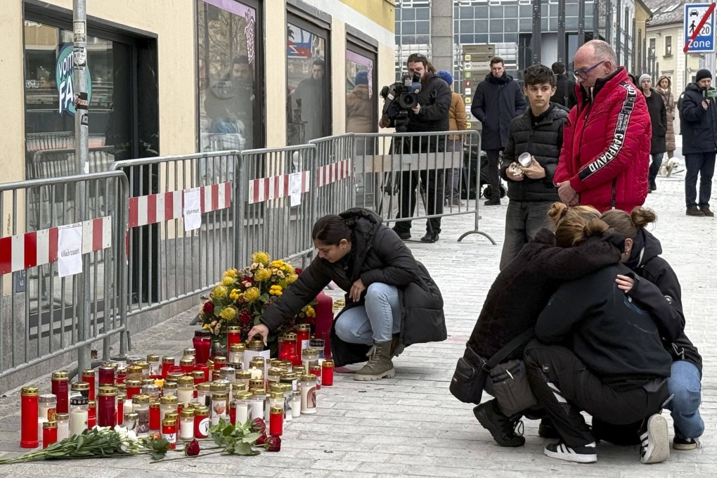 People mourn at a makeshift memorial of candles and flowers in Villach, Austria. Photo: APA via AFP