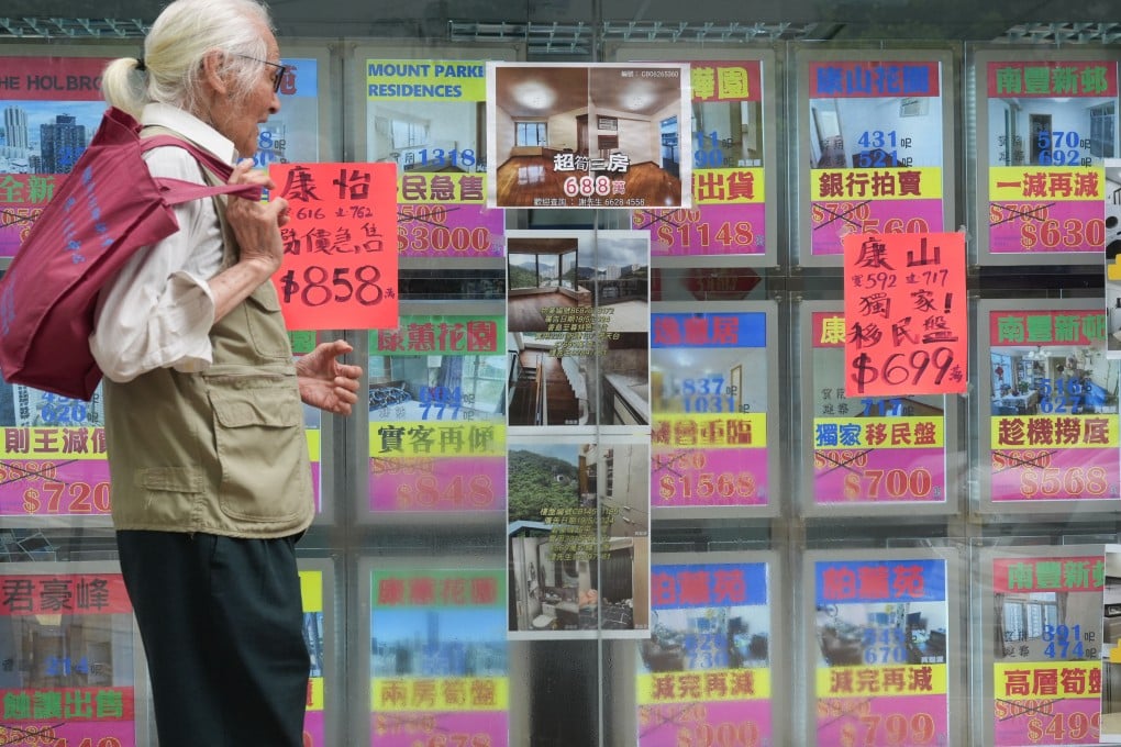 A pedestrian reacts to seeing home prices displayed by a property agency in Tai Koo, Hong Kong, on July 24. Photo: Eugene Lee