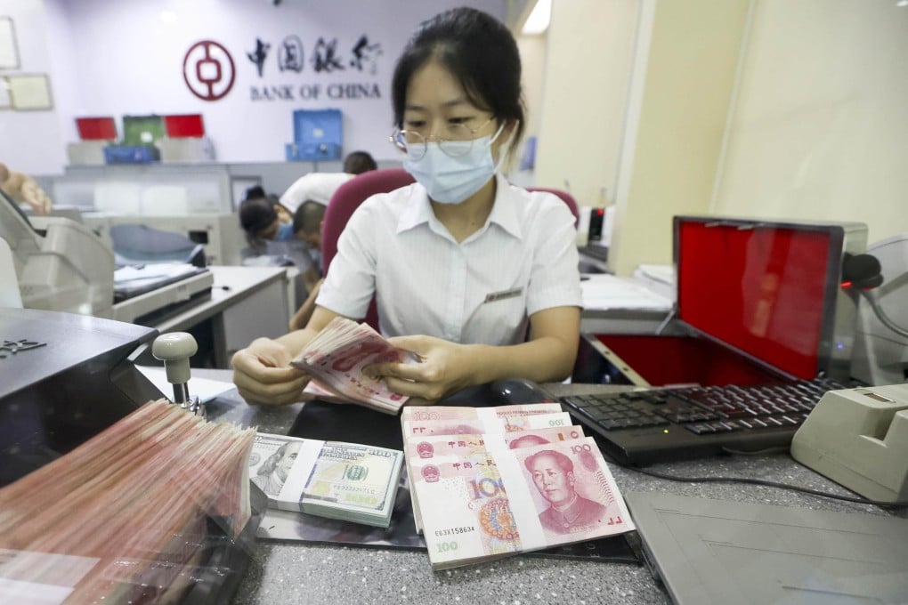 A Bank of China employee counts US and Chinese banknotes at a branch in Taiyuan, Shanxi province, in 2020. Photo: CNS