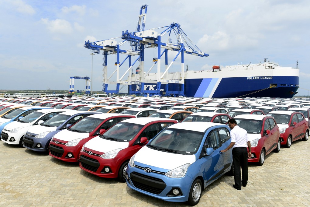 A Sri Lankan official looks at imported cars in the port facility at Hambantota in 2015. Photo: AFP